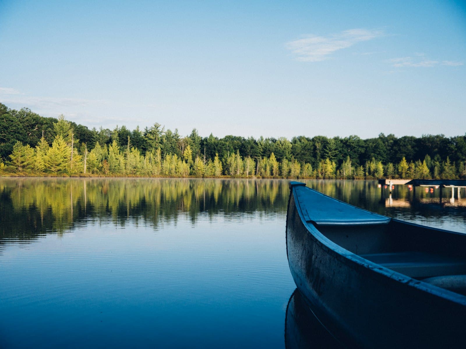 A canoe pulled up on a calm blue lake