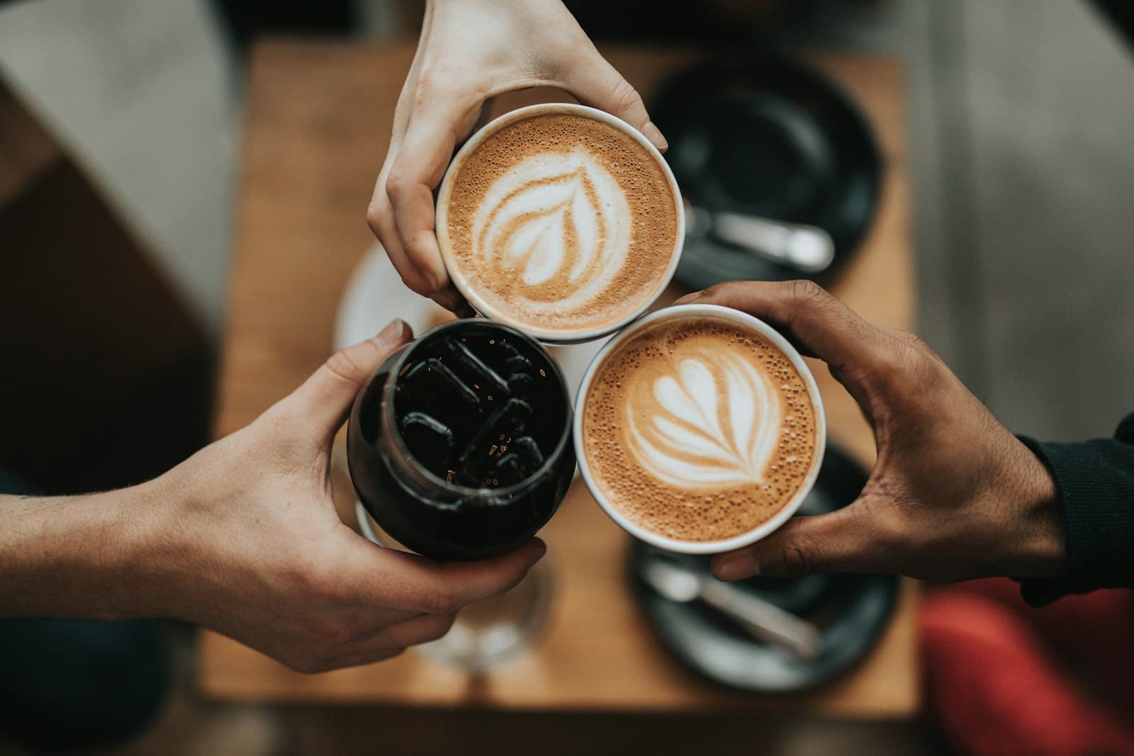 Hands gathered around mugs of coffee on a table