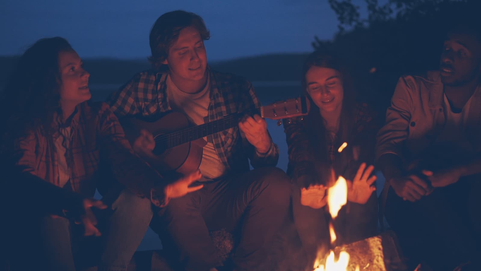 A guitar by the campfire after dark